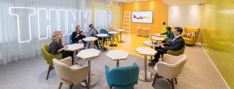 Kreativt konferensrum i Stockholm med gula väggar och neonskylt.
